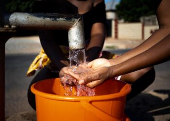 african woman pouring water recipient outdoors 23 2149021910 1