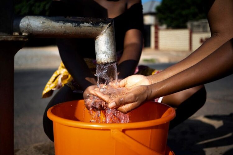 african woman pouring water recipient outdoors 23 2149021910 1