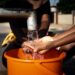 african woman pouring water recipient outdoors 23 2149021910 1