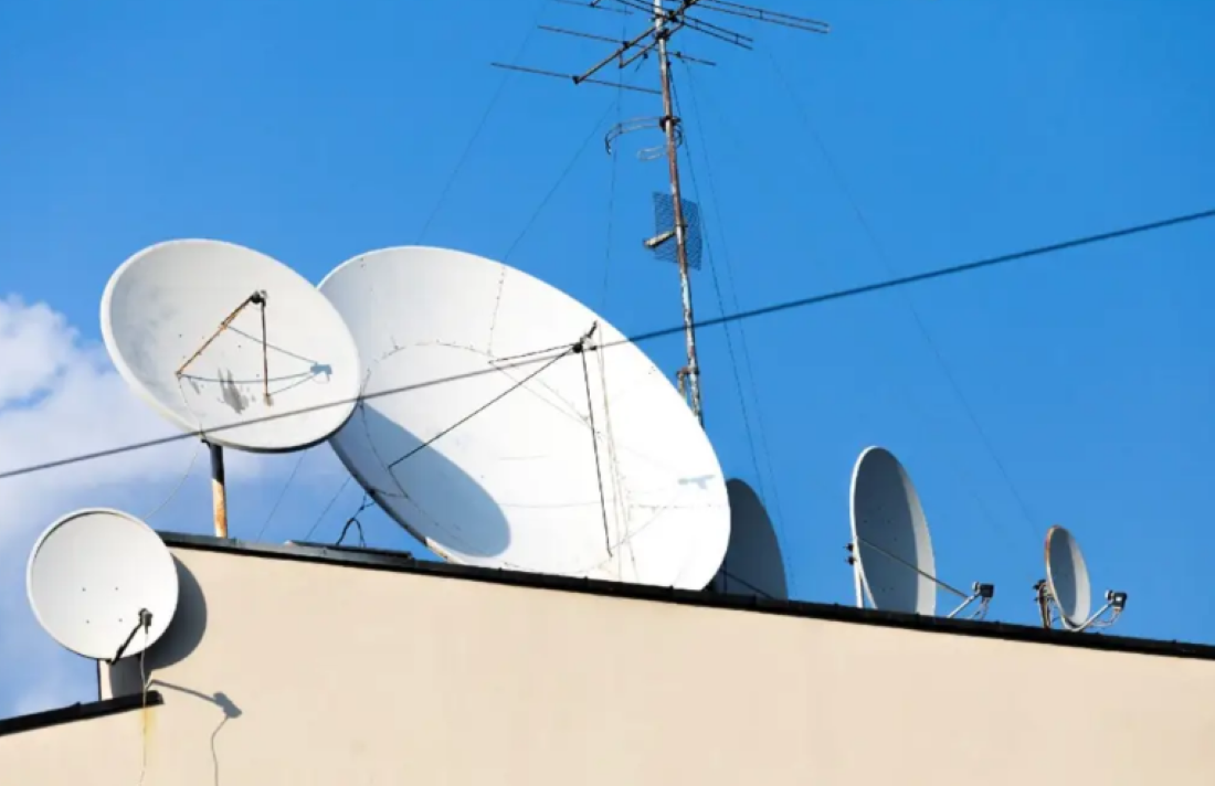 Antenas parabólicas instaladas em telhado para recepção de sinal digital.