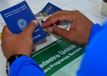 Homem segurando a Carteira de Identidade com logo do Cadastro Único