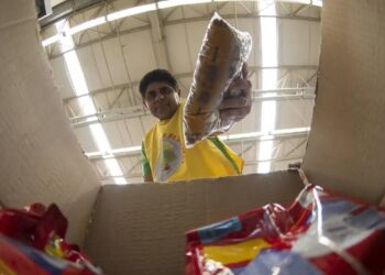 Imagem de um homem pegando um alimento de uma caixa