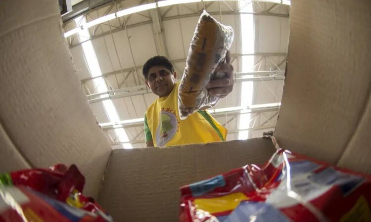 Imagem de um homem pegando um alimento de uma caixa