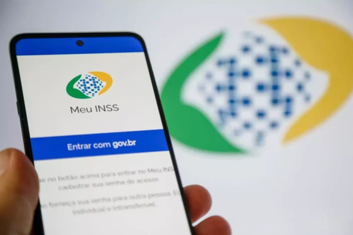 Celular na mão de uma pessoa aberto no App Meu INSS