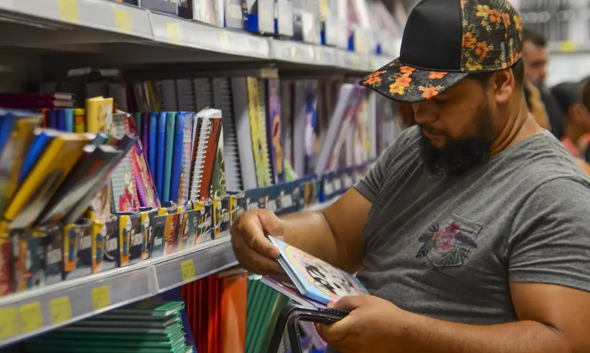 Imagem de um pai comprando o material escolar da filha com o Cartão Material Escolar