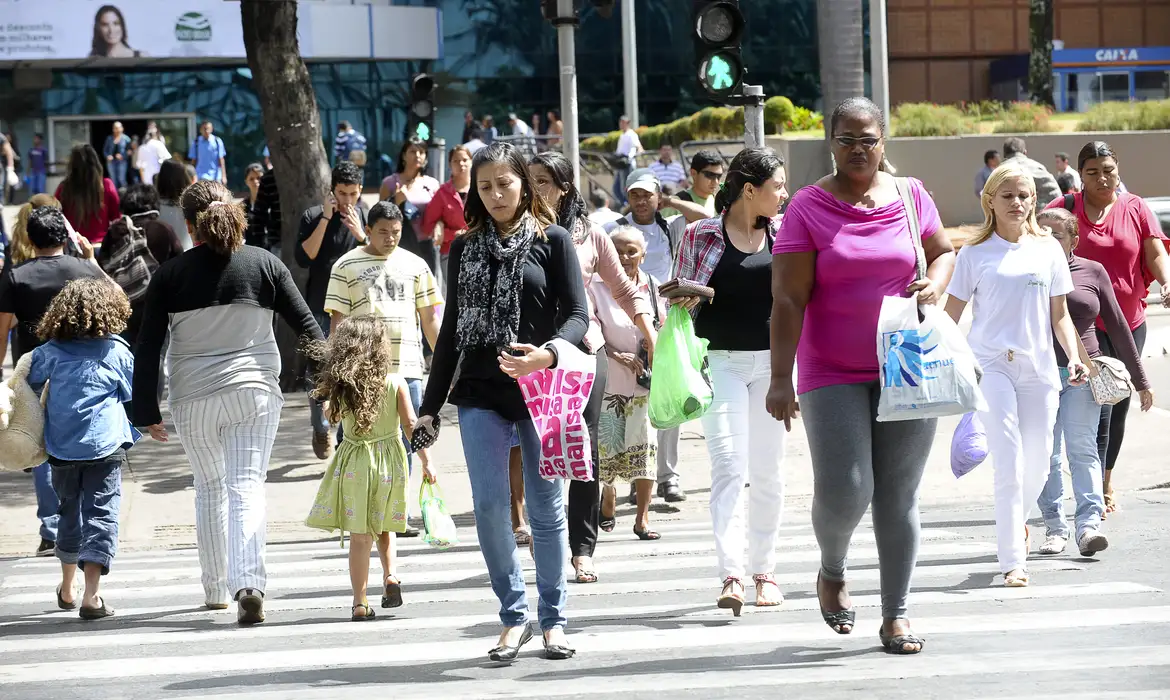 Pessoas beneficiárias do Bolsa do povo andando na rua