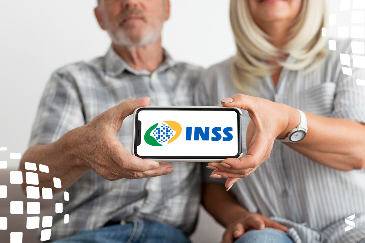 Casal de idosos segurando um celular com o logo do INSS na tela.