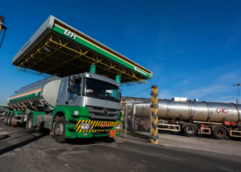 Caminhão de combustível da Petrobras carregando óleo em uma base de distribuição, simbolizando a parceria com o governo para capacitar famílias do CadÚnico.