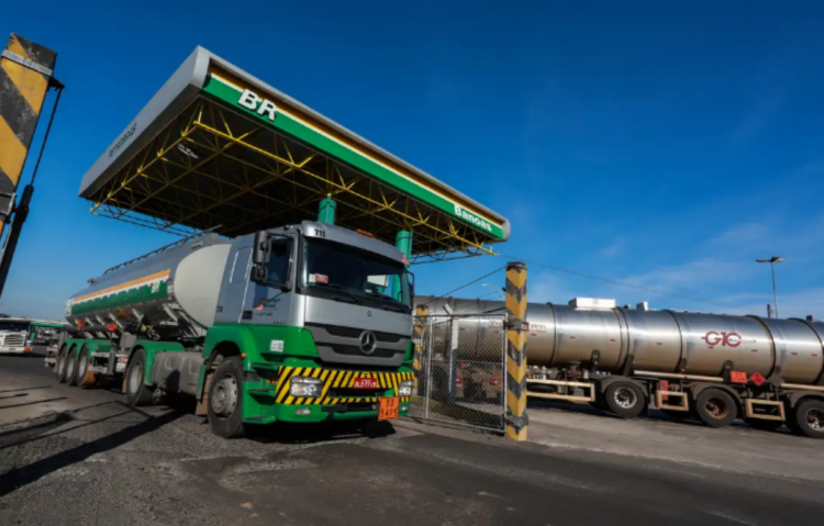 Caminhão de combustível da Petrobras carregando óleo em uma base de distribuição, simbolizando a parceria com o governo para capacitar famílias do CadÚnico.