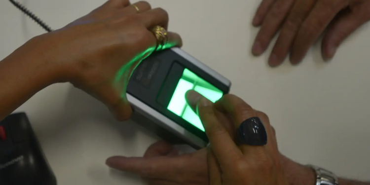 Pessoa usando biometria digital, exemplificando o processo de verificação para o Bolsa Família.