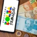 Cédulas de real e smartphone com o logo do Bolsa Família