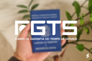 Mão segurando carteira de trabalho com o logotipo do FGTS em destaque.