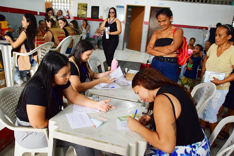 Pessoas realizando a atualização cadastral em um posto de atendimento.