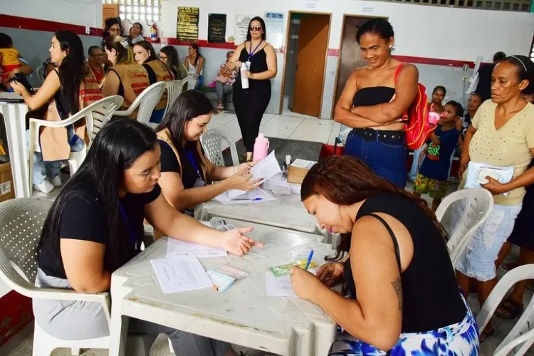 Pessoas participam do mutirão deatualização do Cartão Alimentação em um local de atendimento.