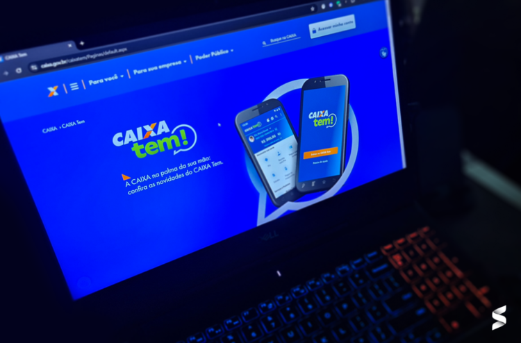 Página do site da Caixa Tem aberta em um notebook, destacando informações sobre pagamentos do programa.