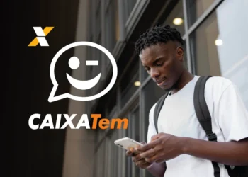 Homem com mochila olhando para seu celular, com o logo do Caixa Tem em destaque.