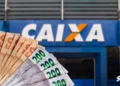 Notas de dinheiro em frente a uma agência da Caixa Econômica Federal.