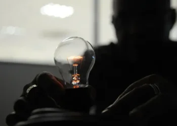Lâmpada sendo instalada, simbolizando o início do fornecimento de energia.