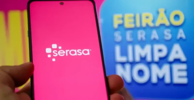 Aplicativo da Serasa em um smartphone com o banner do Feirão Limpa Nome ao fundo.