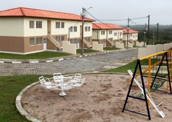 Conjunto habitacional do programa Minha Casa Minha Vida com parque infantil na área comum.