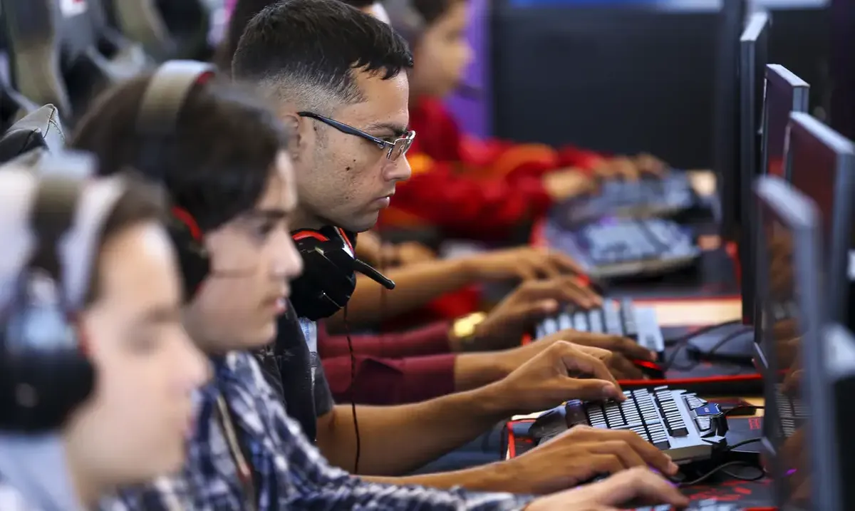 Jovens participando de treinamento em um computador, simbolizando a capacitação no programa Menor Aprendiz.