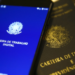 Carteira de Trabalho Digital exibida em um celular ao lado de Carteiras de Trabalho impressas, representando mudanças no Seguro-Desemprego em 2025.