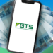 "Imagem mostrando notas de 100 reais ao redor de um celular com o logotipo do FGTS, representando as mudanças no saque-aniversário do FGTS em março."