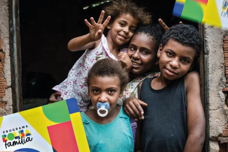 Família recebendo benefícios do programa Bolsa Família, com crianças sorrindo e mostrando a interação com o cartão.