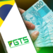 Celular exibindo o logo do FGTS ao lado de notas de R$ 100 sendo seguradas por uma mão.