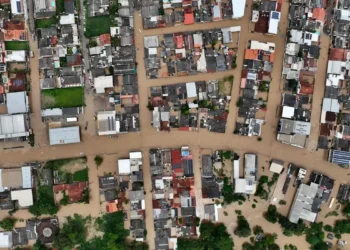 "Vista aérea de uma área urbana alagada, ilustrando as consequências de desastres naturais que podem ser cobertos pelo saque calamidade."