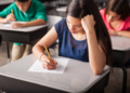 Estudantes fazendo prova em sala de aula, representando alunos beneficiados por bolsas de cursinhos populares.