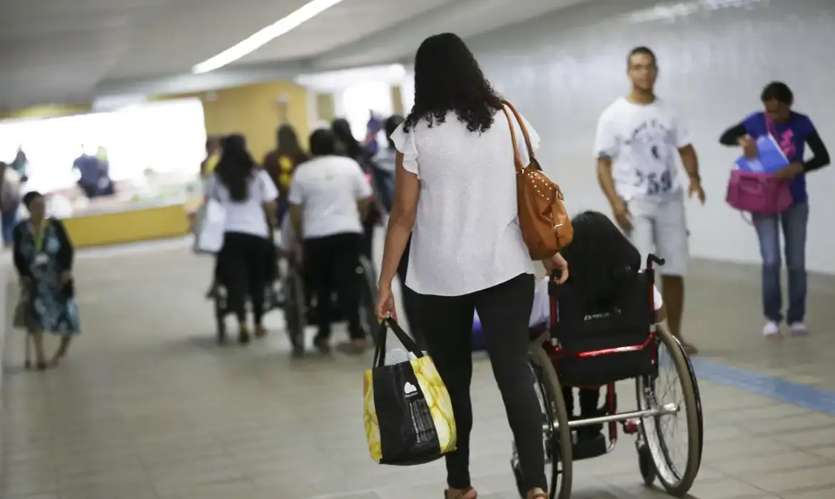 Imagem de pessoas no transporte público, representando famílias com idosos ou pessoas com deficiência.