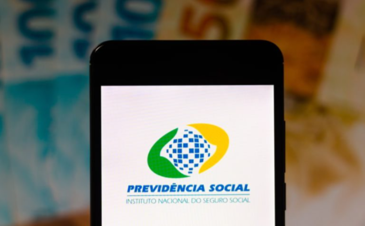 Tela de celular exibindo o logotipo do INSS, com notas de dinheiro desfocadas ao fundo.