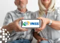 Casal de aposentados segurando um celular com o logotipo do INSS, representando o adiantamento dos pagamentos.