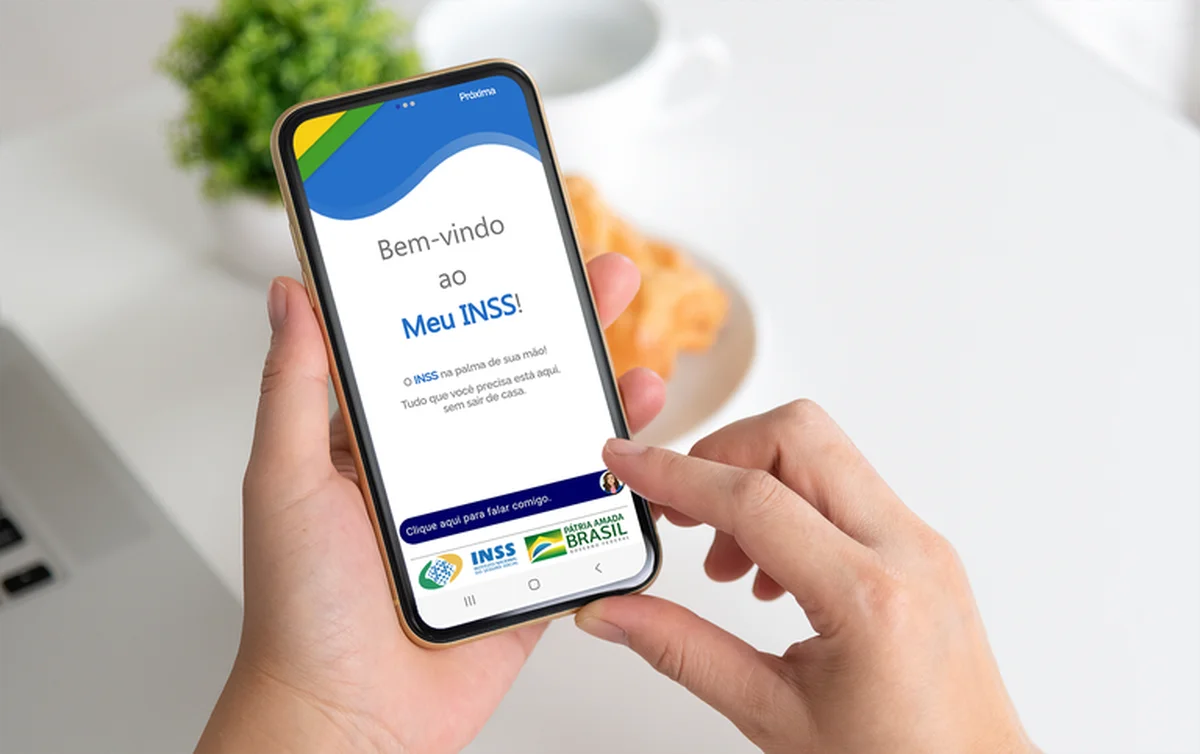 Pessoa usando o aplicativo Meu INSS em um smartphone, acessando serviços como a prova de vida.