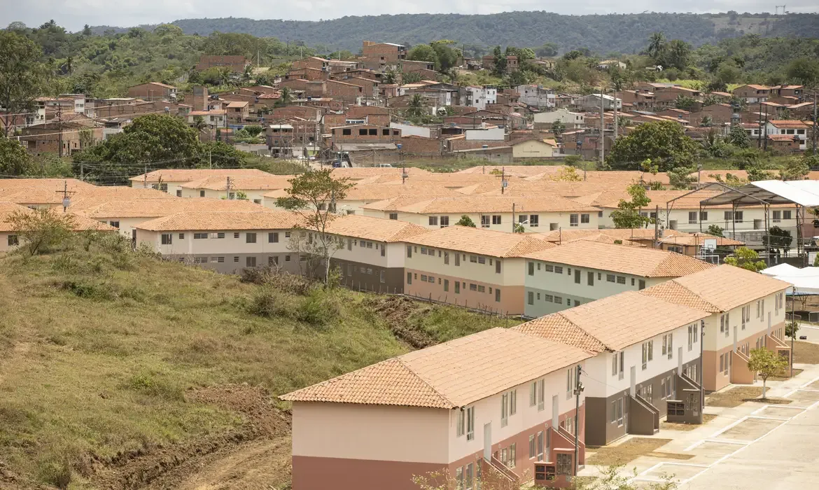 Conjunto habitacional rural do programa Minha Casa, Minha Vida, com casas em uma área periférica.