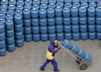 Homem transportando botijões de gás, representando a distribuição de gás para o Auxílio Gás.