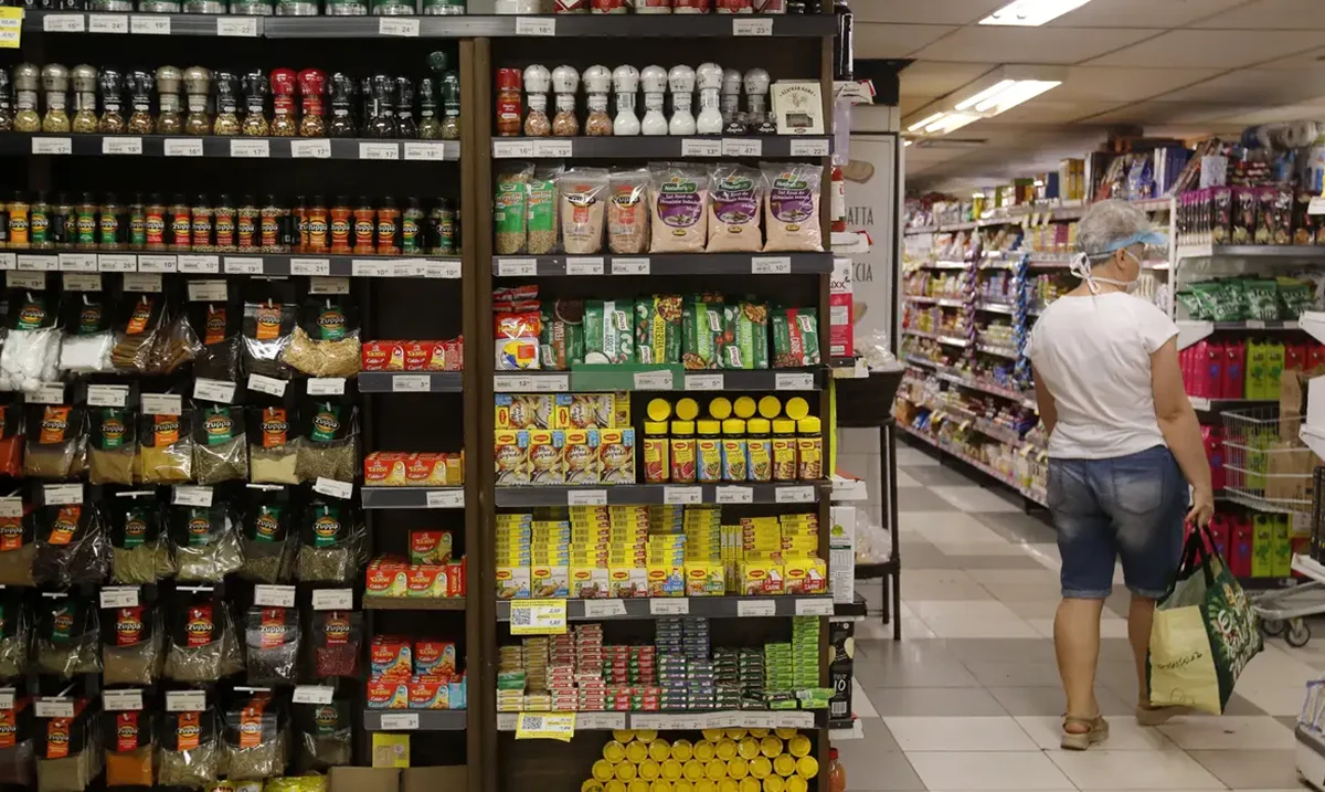 Imagem de prateleira de supermercado com diversos alimentos básicos, representando a redução das tarifas de importação desses produtos.