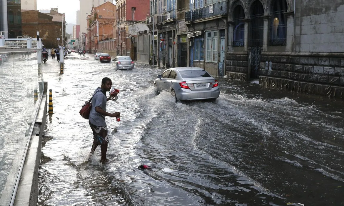 Rua alagada após chuvas intensas, ilustrando os danos causados pelas fortes chuvas na cidade.