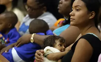 Mãe amamentando seu filho, refletindo a prioridade do Programa Bolsa Família no acompanhamento da saúde dos beneficiários.