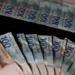 "Cédulas de R$ 100 e R$ 200, representando o pagamento do 13º salário."