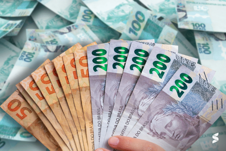 Dinheiro em cédulas brasileiras com destaque para valores de R$50 e R$200, representando a liberação de valores pelo governo.