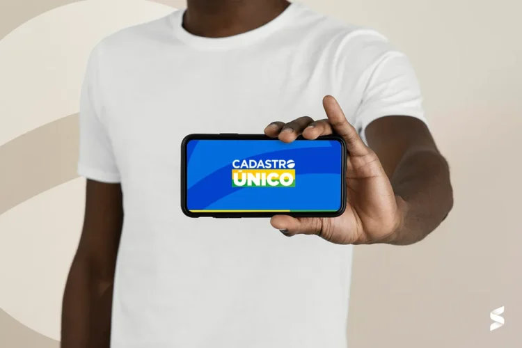"Pessoa segurando um celular com o logo do Cadastro Único na tela, simbolizando a consulta ao CadÚnico."