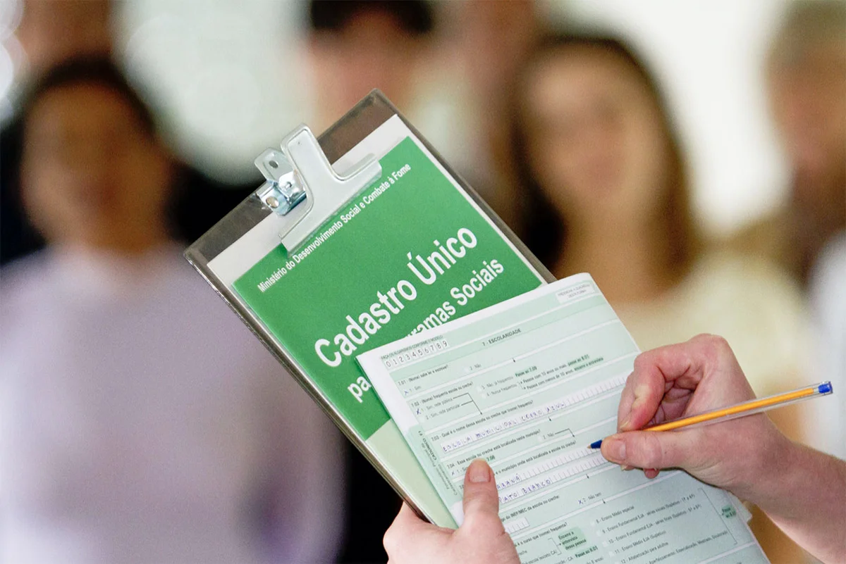 Pessoa preenchendo o formulário do Cadastro Único com o logo visível do programa.