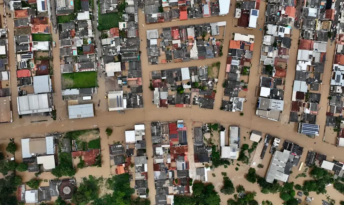 "Vista aérea de uma área urbana inundada, ilustrando os impactos de uma calamidade."