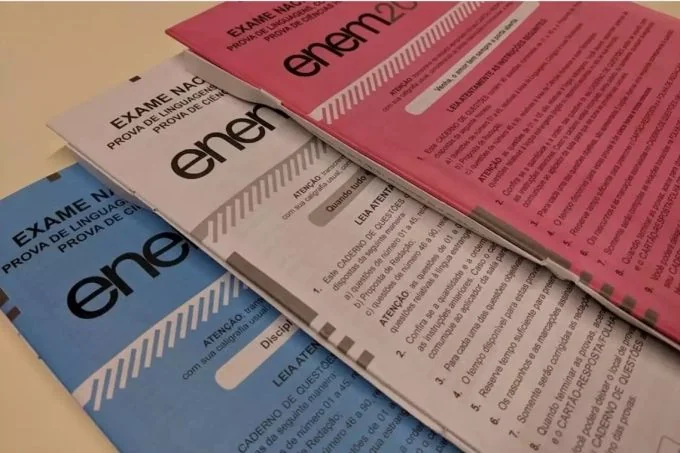 Capa do caderno de provas do Enem 2025, com as cores azul, vermelho e rosa, destacando a inscrição 'Exame Nacional do Ensino Médio'