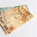 Notas de cinquenta reais representando benefício social disponível para retirada
