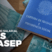 Carteira de trabalho ao lado de cédulas de 100 reais com destaque para o abono salarial PIS/Pasep