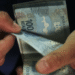 Pessoa segurando cédulas de R$ 100, simbolizando o valor do décimo terceiro salário de um salário mínimo.