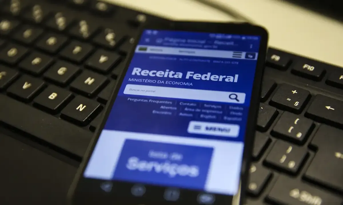 Pessoa acessando o site da Receita Federal para acompanhar a restituição do Imposto de Renda.